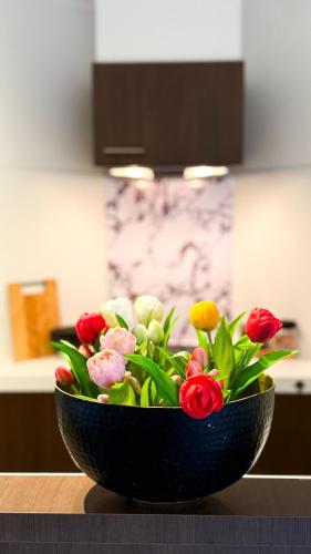 a black bowl filled with flowers on a table at COCO a unique quiet home with private parking in Laarne