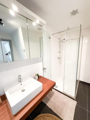a bathroom with a white sink and a shower at COCO a unique quiet home with private parking in Laarne