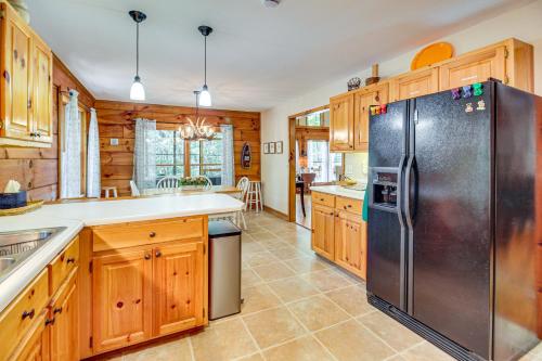 a kitchen with wooden cabinets and a stainless steel refrigerator at North Georgia Cabin with Hot Tub and Community Perks! in Jasper