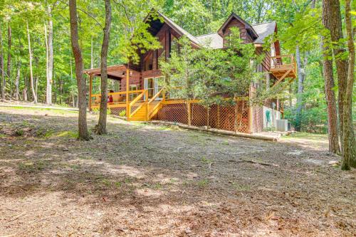 a log cabin in the woods with a deck at North Georgia Cabin with Hot Tub and Community Perks! in Jasper