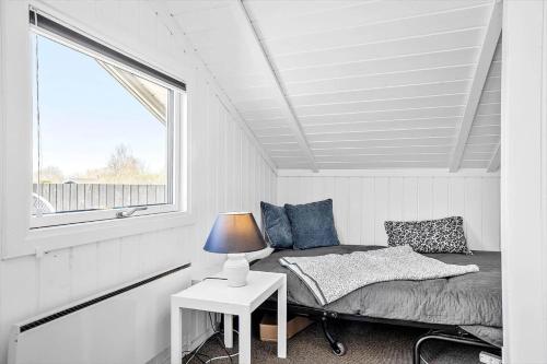 a bedroom with a bed and a table with a lamp at SL310-Slagelse-Birkevej-49 in Slagelse