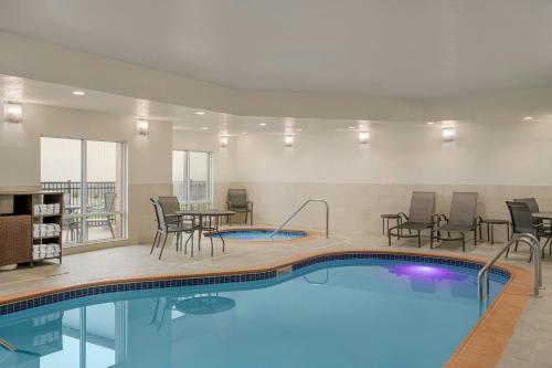 a pool in a hotel room with chairs and a table at Fairfield Inn & Suites Bloomington in Bloomington