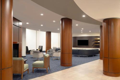 a lobby with a waiting area with chairs and a tv at Courtyard Boston-South Boston in Boston