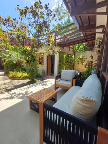 a patio with a couch and a table and benches at Pousada Rubi in Abraão