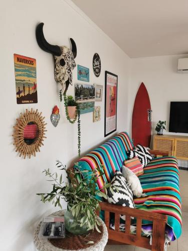 a living room with a couch with colorful pillows at Blue Moon - a Bohemian retreat at Papamoa Beach in Tauranga