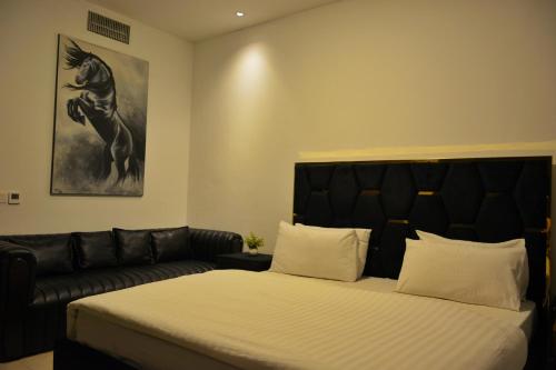 a bedroom with a bed and a couch at Premium Guest House - Pentasquare in Lahore