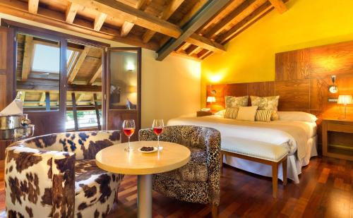 a hotel room with a bed and a table and chairs at Izan Puerta de Gredos in El Barco de Ávila