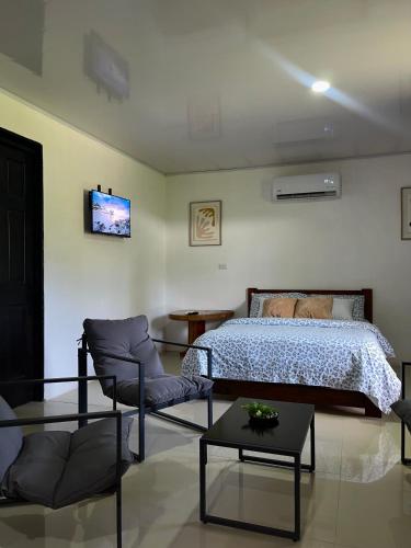 a bedroom with a bed and a couch and a table at Corcovado House With AC in Puerto Jiménez