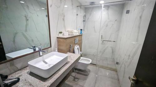 a bathroom with a sink and a shower and a toilet at Premium Guest House - Pentasquare in Lahore