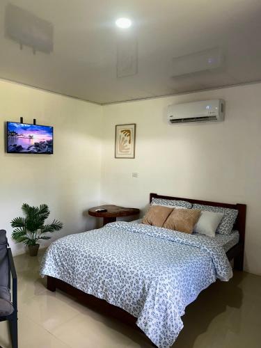 a bedroom with a bed with a blue and white comforter at Corcovado House With AC in Puerto Jiménez