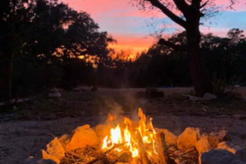 a fire pit in a field at sunset at Dry Creekside Casita in Fischer