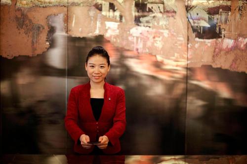 a woman is standing in front of a wall at Suzhou Marriott Hotel in Suzhou