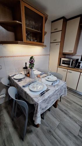 a table in a kitchen with a white table cloth at Casa fantástica en zona tranquila Un alojamiento para todos Nuestra casa es perfecta tanto para familias y amigos que buscan descanso, como para ciclistas que desean explorar la zona Para ciclistas ofrecemos un espacio seguro para guardar bicicle in Girona