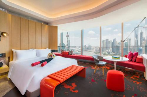 a hotel room with a bed and a large window at W Shanghai - The Bund in Shanghai