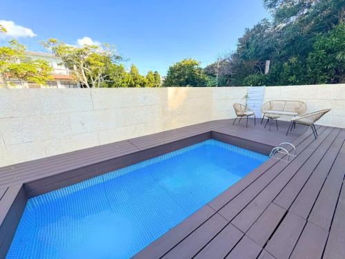a swimming pool with a table and chairs on a wooden deck at OKINAWA POOLWILLA ONNA 4A - Vacation STAY 48422v in Baba