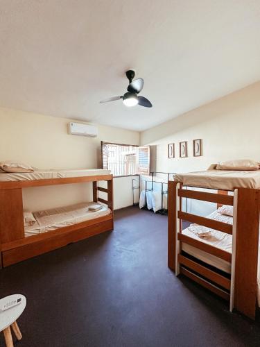 Zimmer mit 2 Etagenbetten und einem Deckenventilator. in der Unterkunft CasAMAR - casa de praia na terra das piscinas naturais - PE in São José da Coroa Grande