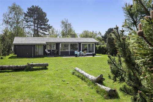 a cabin in the middle of a yard with a log at SL274-Korsor-Havstokken-16 in Korsør