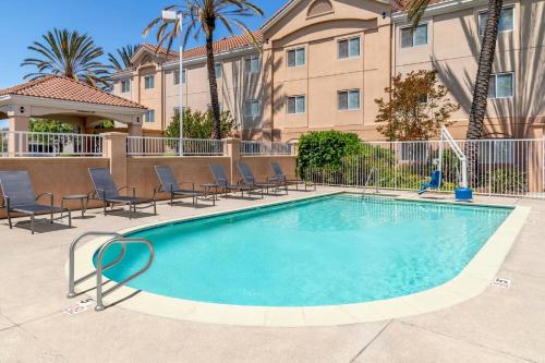 a swimming pool with chairs and a building at Fairfield Inn & Suites by Marriott San Francisco San Carlos in San Carlos