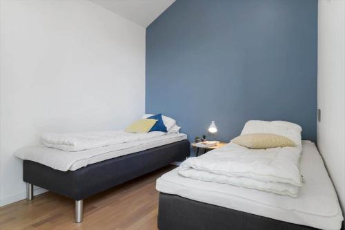 two beds in a room with a blue wall at 20413-Samso-Ballen-Strandpark-16 in Ballen