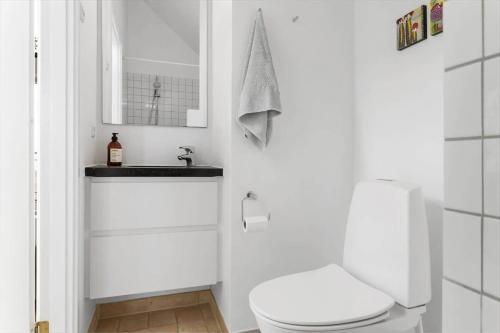 a white bathroom with a toilet and a sink at 20413-Samso-Ballen-Strandpark-16 in Ballen