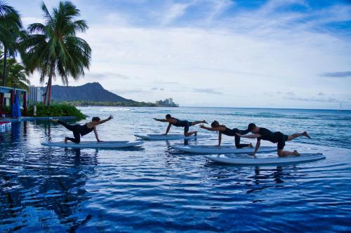 a group of people on surfboards in the water at Sheraton Waikiki Beach Resort in Honolulu