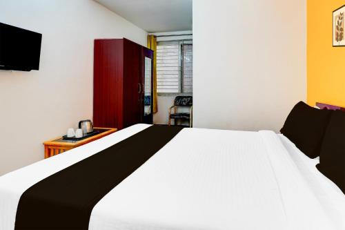 a bedroom with a large white bed and a desk at Super Collection O Banaswadi in Bengaluru