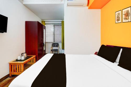 a bedroom with a large bed and a chair at Super Collection O Banaswadi in Bengaluru