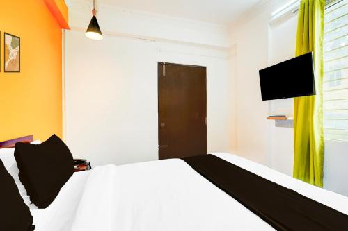 a bedroom with a white bed and a flat screen tv at Super Collection O Banaswadi in Bengaluru