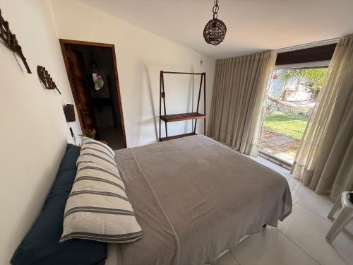 a bedroom with a bed and a window at Casa Praia in Luis Correia