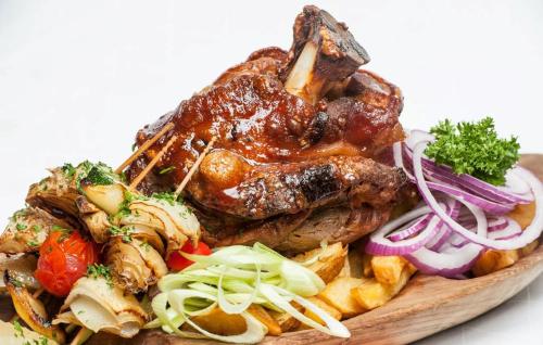 a plate of food with meat and vegetables at Otthonos lakás in Kerepes