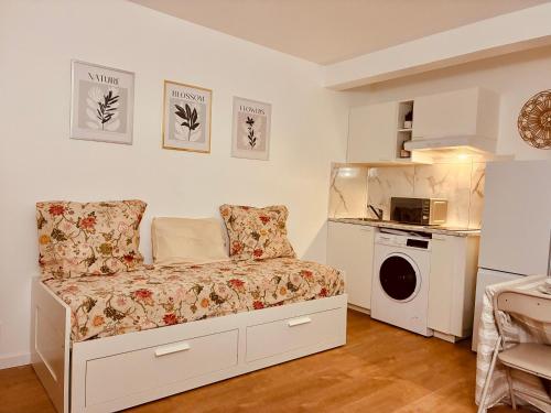 a small bedroom with a bed and a microwave at Studio lumineux, 10min de Paris in Issy-les-Moulineaux
