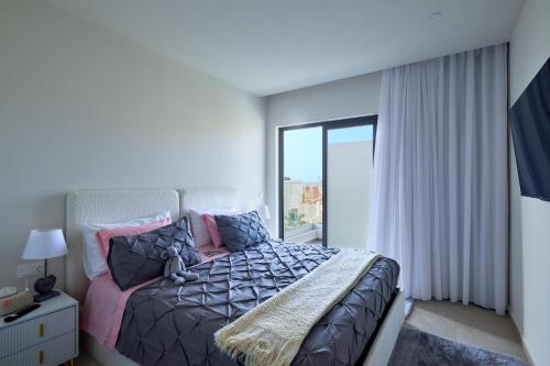a bedroom with a bed and a large window at Apartamentos Golfinho Dourado in Santa Maria