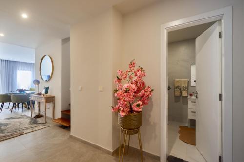 a living room with a vase of flowers on a stool at Apartamentos Golfinho Dourado in Santa Maria