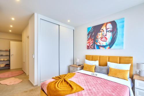 a bedroom with a bed with a painting on the wall at Apartamentos Golfinho Dourado in Santa Maria