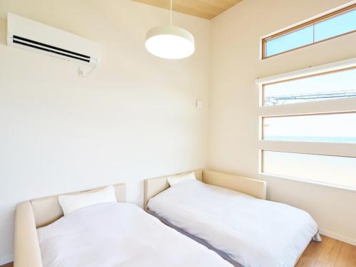 two beds in a room with a window at T,square - Vacation STAY 11448v in Awaji