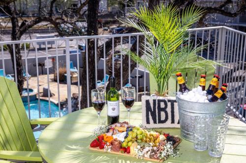 een tafel met twee glazen wijn en een bord eten bij Shared Heated Pool Balcony BBQ Near Downtown in New Braunfels