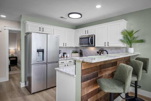 a kitchen with white cabinets and a stainless steel refrigerator at Shared Heated Pool Balcony BBQ Near Downtown in New Braunfels