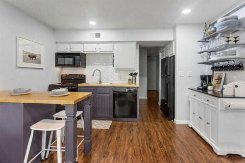 a kitchen with white cabinets and a wooden floor at Shared Hot Tub & Pool Grill River Access in New Braunfels