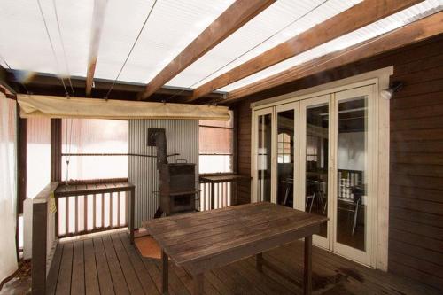 a wooden porch with a wooden table on a deck at Kitakaruizawa Sweet Grass - Vacation STAY 18432v in Kita-karuizawa