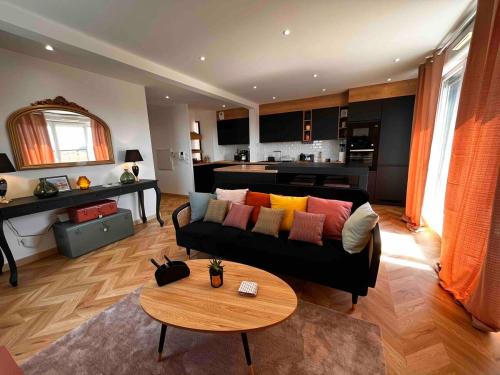 a living room with a couch and a table at Chic apartment with panoramic view in Caen