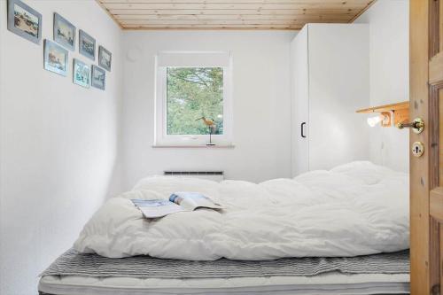 a large white bed in a room with a window at 20137-Samso-Topmejsevej-8 in Nordby