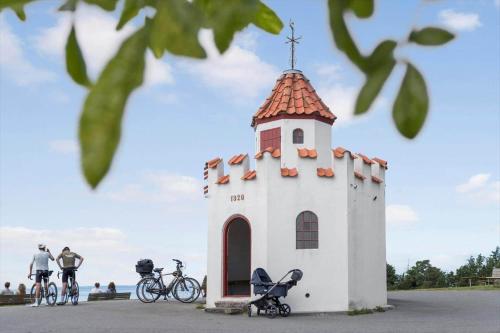 a small white tower with a red roof with two bikes at 20137-Samso-Topmejsevej-8 in Nordby