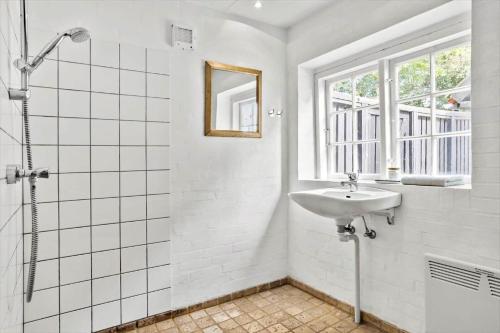 a white bathroom with a sink and a window at 20509-Samso-Egevej-13 in Onsbjerg