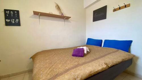 a bedroom with a bed with purple sheets and blue chairs at נווה במדבר - שופץ ב-2025! צמוד ל BGU וסורוקה - אינטרנט סיבים, Google TV ומיזוג מלא in Beer Sheva