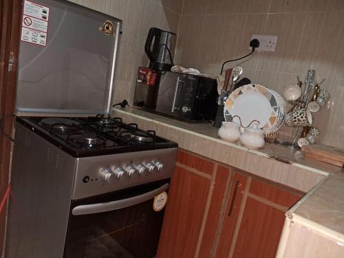 una cocina con estufa y encimera en Nakuru cozy stay, en Nakuru