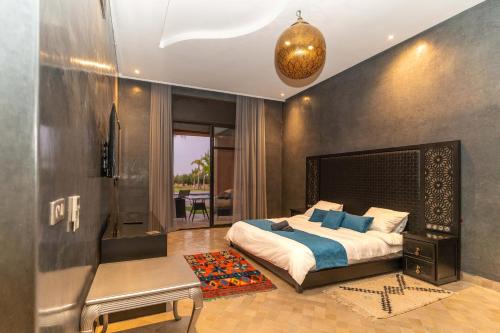 a bedroom with a large bed and a table at PalmStay Marrakech villa luxeuse in El Aggada