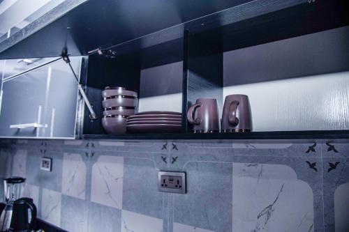 - une cuisine avec un comptoir avec des assiettes et des ustensiles dans l'établissement PEK Villa, Cozy Luxury Hideouts, 25 mins from Airport, à North Legon