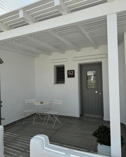 a patio with a table and chairs and a door at SOPHILIA SUITES in Koufonisia