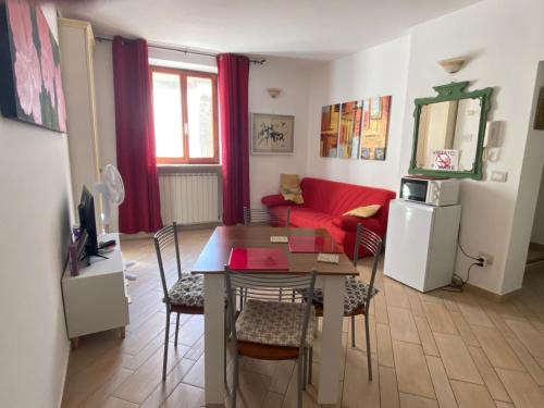 Una sala de estar con una mesa y un sofá rojo. en Casa Ischia, en Perugia