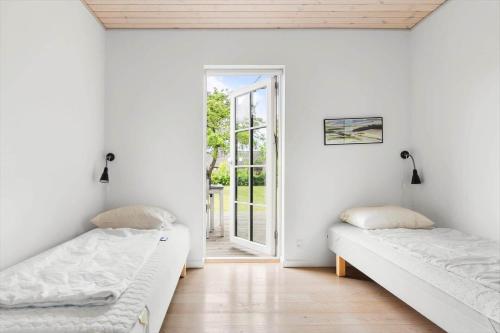 two beds in a room with an open door at 20149-Samso-Landevejen-45 in Nordby